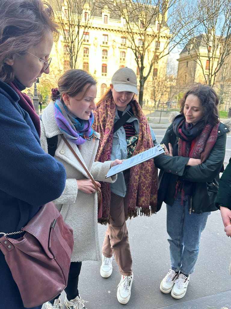 L'image montre 5 personnes debout autour d'un plan que l'une d'entre elles tient