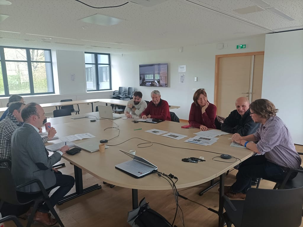 L'image montre 8 personnes assises autour d'une table, en train de présenter des fiches préalableme,nt remplie. Eles sourient
