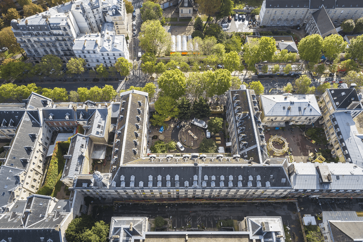 L4image montre un bâtiment vu du ciel, formant un U avec une cour arborée au centre