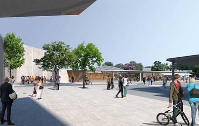 L'image représente un grand parvis clair, on voit les lettrines "gare Sevran-Beaudottes", avec des personnes qui la traversent à pied, à velo, et des abres