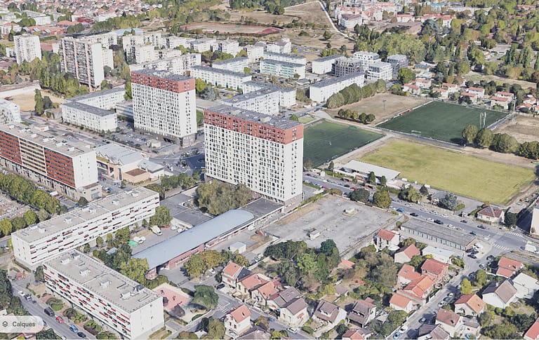 L'image montre un quartier avec des bars d'immeuble eyt des champs vu du ciel