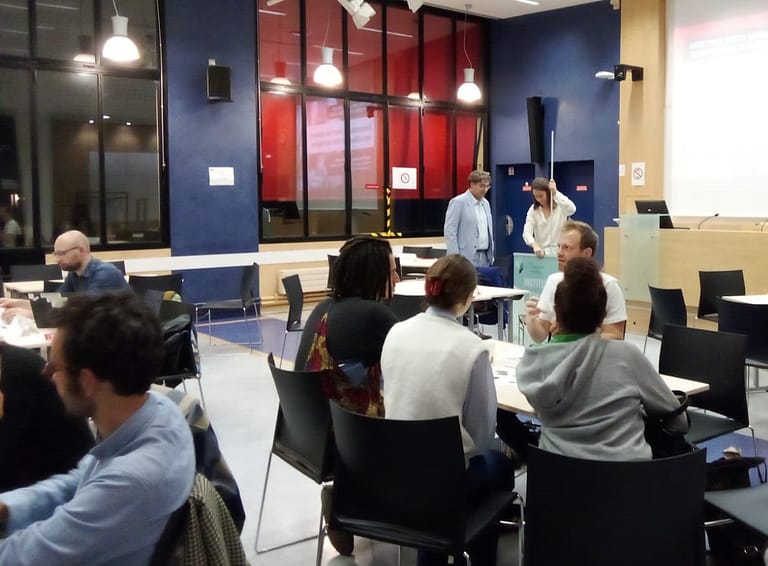 L'image montre une salle avec 4 personnes assises en face d'un homme qui leur présente l'ofre de stage